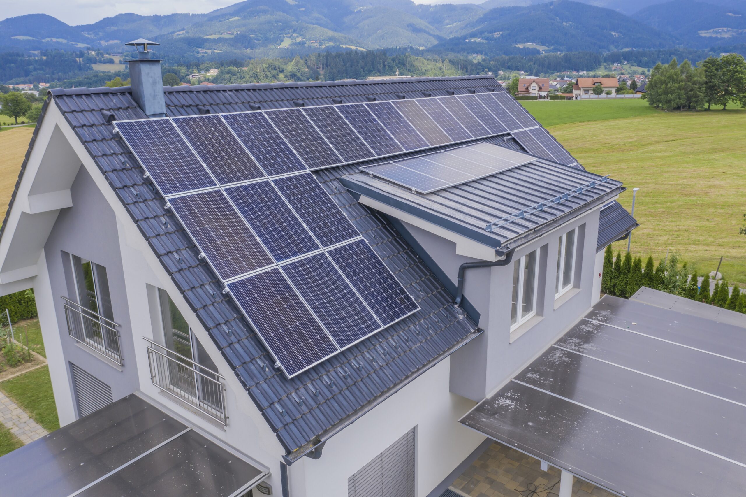 Solar panels arranged across the grey tiled roof of a house
